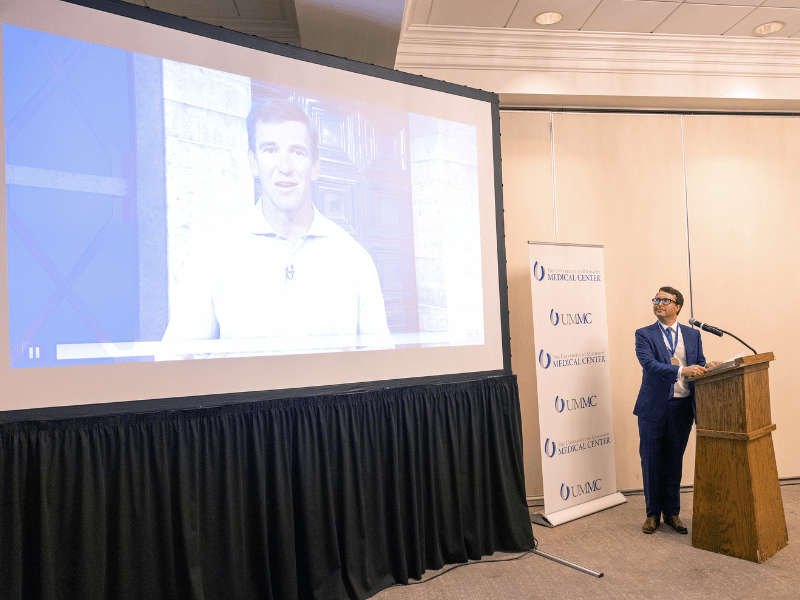 Walker looks to a video of NFL great Eli Manning hailing the launch of the Jabaley-Songcharoen Center for Hand, Upper Extremity & Nerve Surgery.